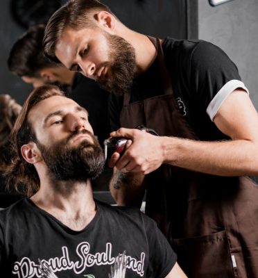 hairdresser-trimming-man-s-beard-with-electric-razor