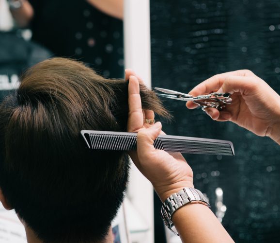 hands-unrecognizable-hairdresser-cutting-male-customer-s-hair-salon